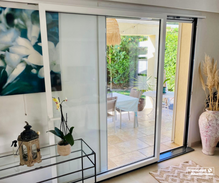 Vue intérieure d’un salon lumineux avec une fenêtre siMple à ouvrant caché - Concept Aluminium 